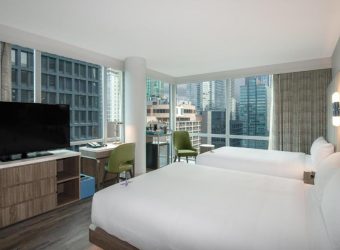 Hoekkamer met twee queensize bedden en stadszicht